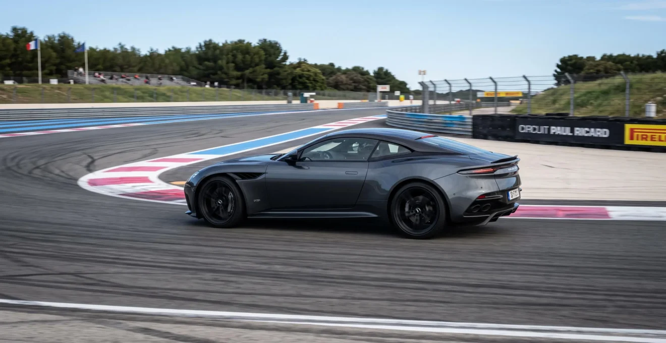 Véhicule sportif haut de gamme circulant sur un circuit automobile homologué avec glissières de sécurité et marquages de piste visibles